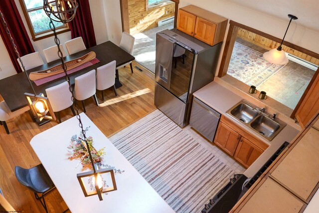 living room with sink, light hardwood / wood-style floors, and baseboard heating