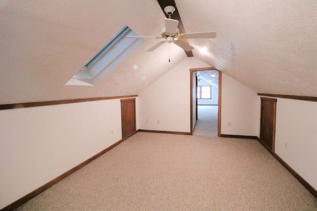 additional living space featuring light carpet, ceiling fan, vaulted ceiling, and a textured ceiling