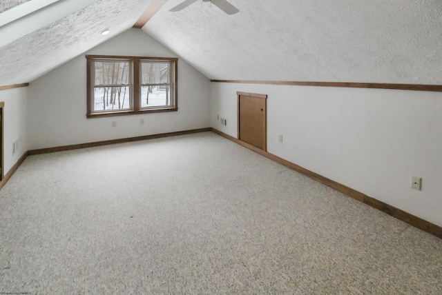 additional living space with light carpet, ceiling fan, vaulted ceiling, and a textured ceiling