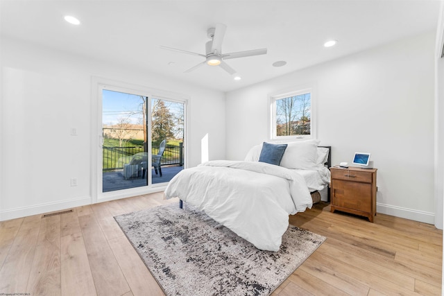 bedroom with ceiling fan, access to exterior, multiple windows, and light wood-type flooring