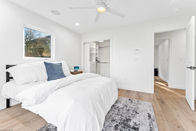 bedroom with ceiling fan, light hardwood / wood-style floors, and a closet