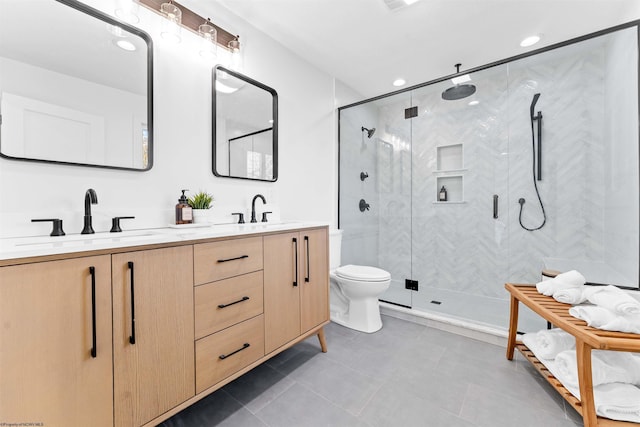 bathroom with vanity, toilet, and a shower with door