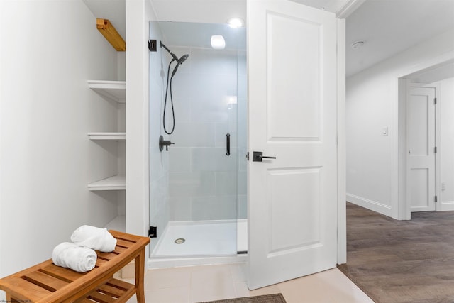 bathroom with a shower with door and hardwood / wood-style flooring