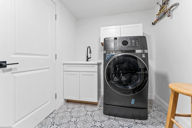 washroom with cabinets, washer / dryer, and sink