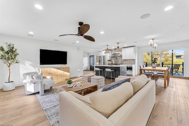 living room with ceiling fan and light hardwood / wood-style floors