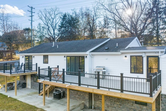 rear view of property with a wooden deck, a patio, and cooling unit