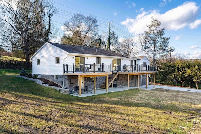 rear view of house with a wooden deck, a yard, and a patio area