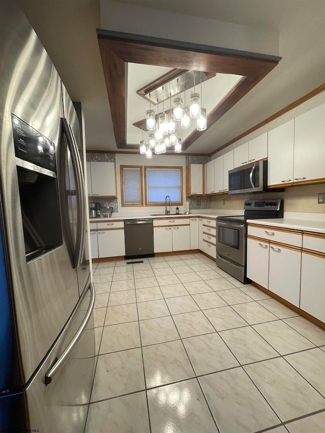 kitchen with pendant lighting, white cabinetry, appliances with stainless steel finishes, and a chandelier