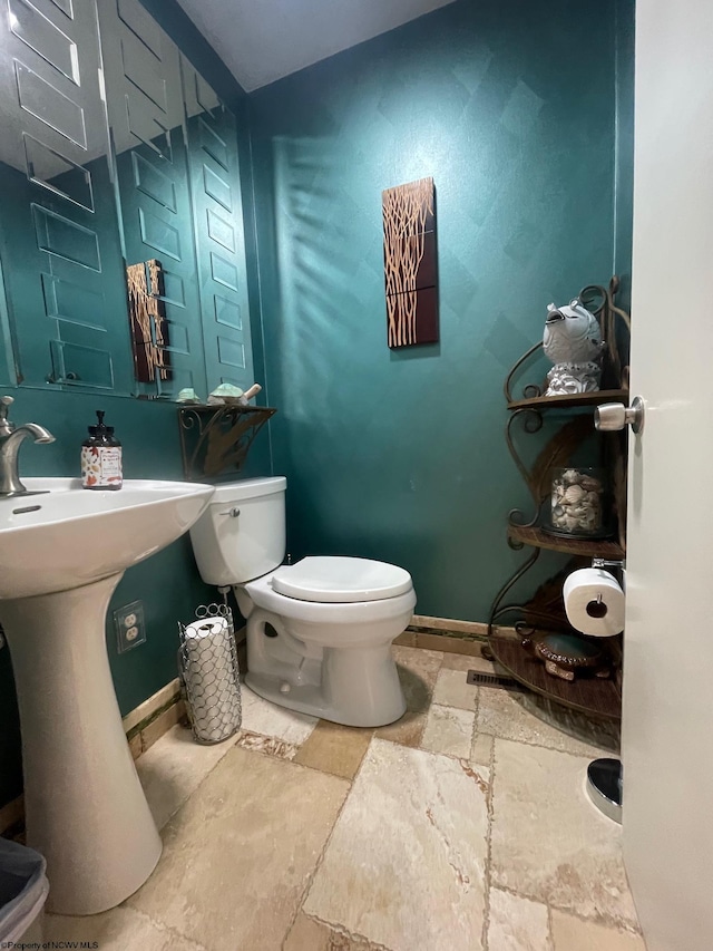 bathroom featuring toilet and tile floors