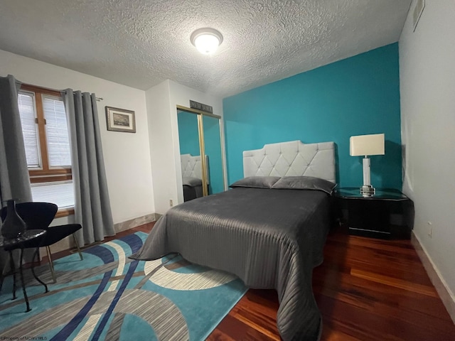 bedroom featuring a textured ceiling and dark wood-type flooring