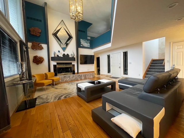 interior space with a tiled fireplace, a chandelier, and light hardwood / wood-style flooring