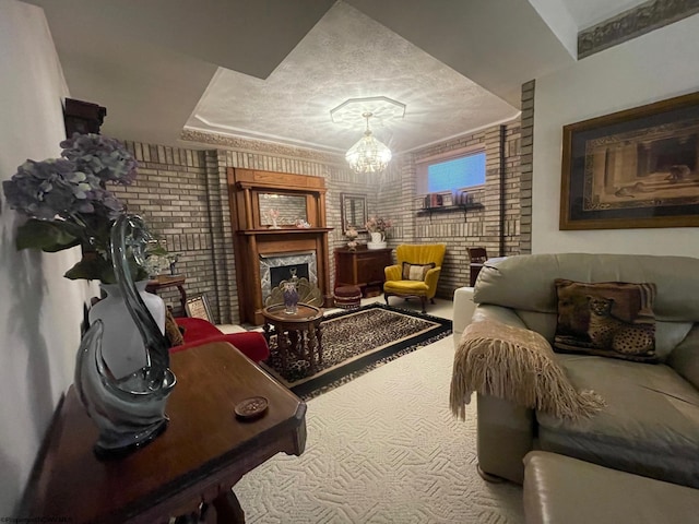 living area featuring brick wall, carpet floors, a chandelier, and a textured ceiling