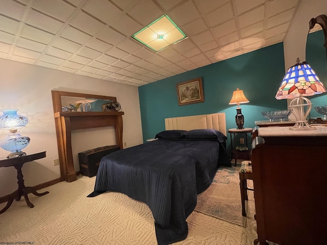 bedroom with a paneled ceiling and light carpet