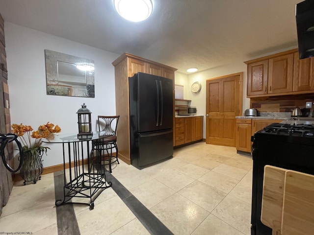 kitchen featuring exhaust hood, light tile floors, and black appliances