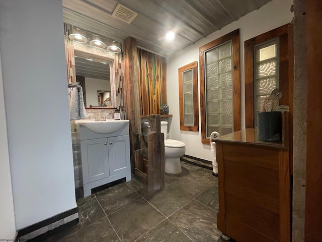 bathroom featuring toilet, vanity, and tile flooring