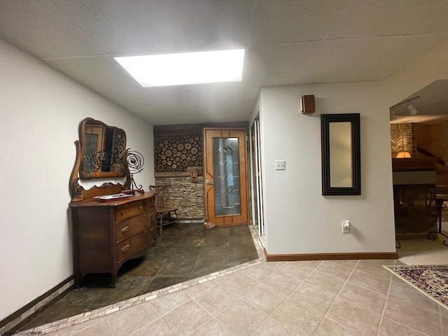 foyer entrance featuring tile floors and a drop ceiling