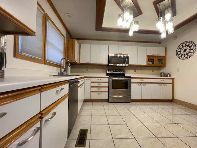 kitchen with pendant lighting, stainless steel appliances, light tile flooring, white cabinets, and sink