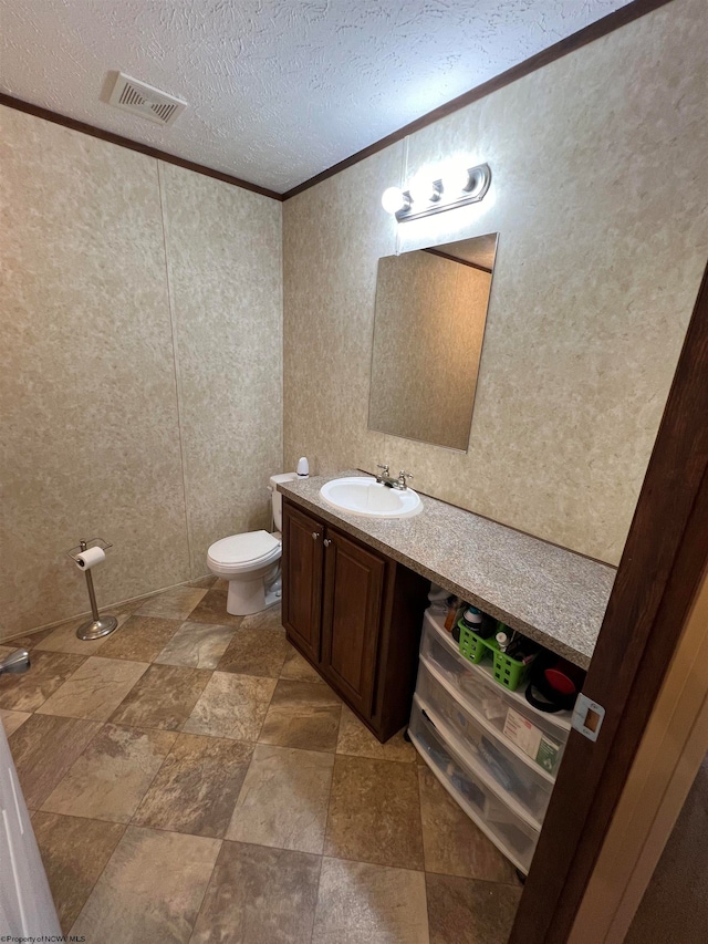 bathroom with oversized vanity, crown molding, tile flooring, toilet, and a textured ceiling