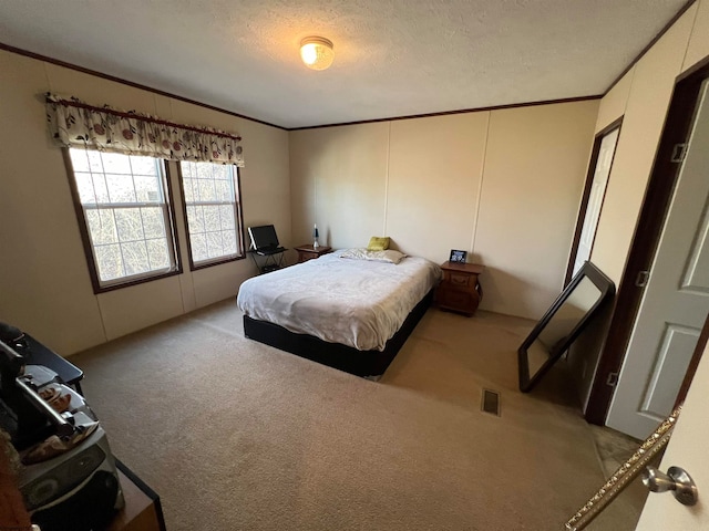 carpeted bedroom with a textured ceiling and ornamental molding