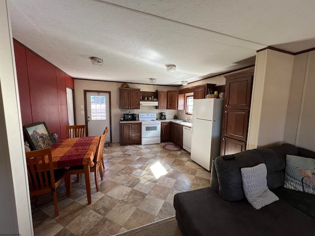 kitchen featuring light tile floors, white appliances, a textured ceiling, and sink