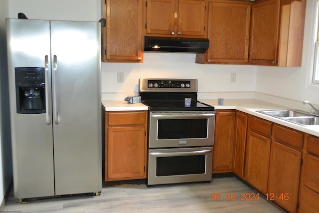 kitchen with sink, light hardwood / wood-style floors, and appliances with stainless steel finishes