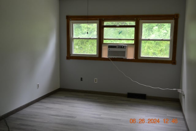 empty room with cooling unit and light hardwood / wood-style flooring