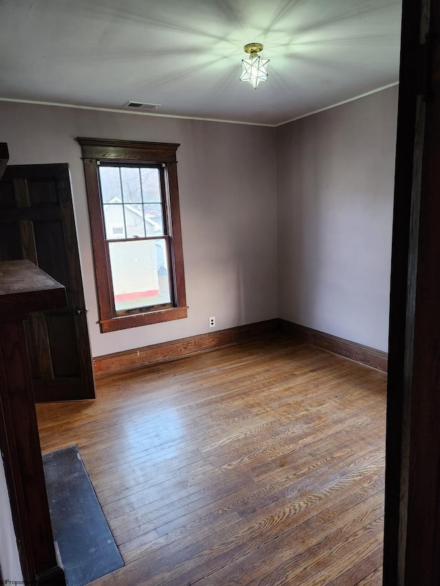 unfurnished room with wood-type flooring and crown molding