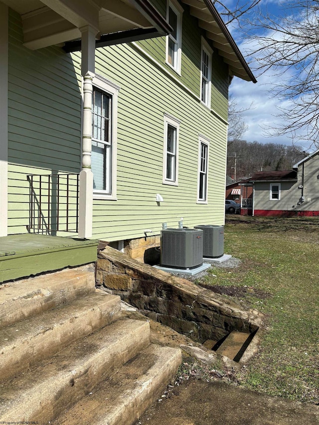 view of home's exterior with a yard and central AC unit