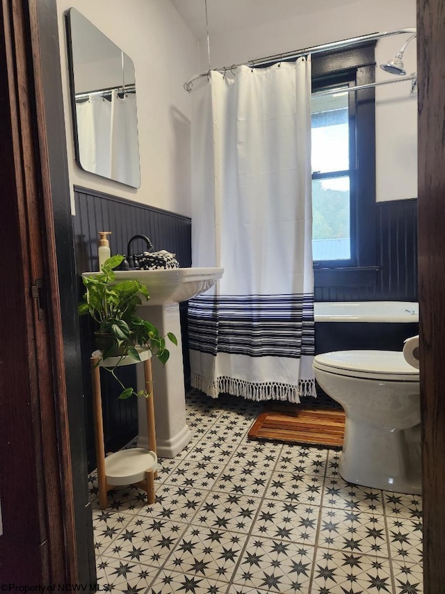 bathroom with toilet, tile patterned floors, and shower / bath combination with curtain