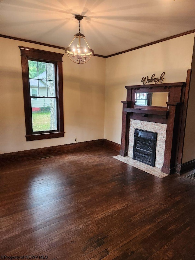 unfurnished living room featuring a notable chandelier, ornamental molding, a tile fireplace, and dark wood-type flooring