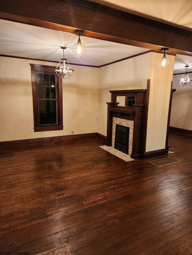 unfurnished living room with crown molding, dark hardwood / wood-style flooring, and a chandelier