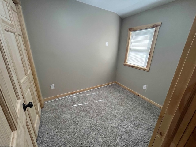 spare room with carpet flooring and lofted ceiling