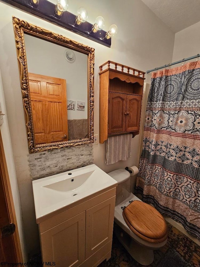 bathroom featuring vanity, a textured ceiling, and toilet