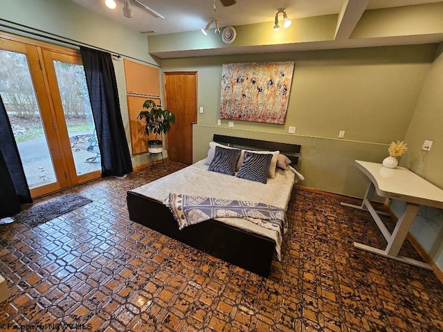 tiled bedroom featuring french doors, access to outside, multiple windows, and track lighting