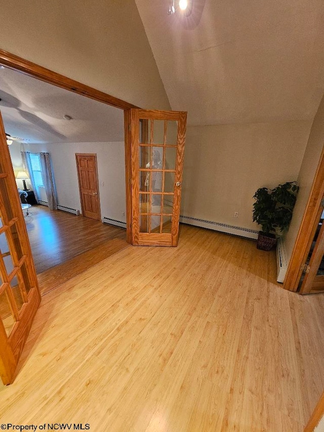 additional living space with light hardwood / wood-style floors, ceiling fan, lofted ceiling, and baseboard heating