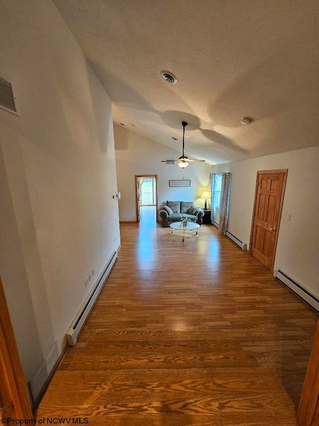 hallway featuring baseboard heating, vaulted ceiling, and hardwood / wood-style flooring