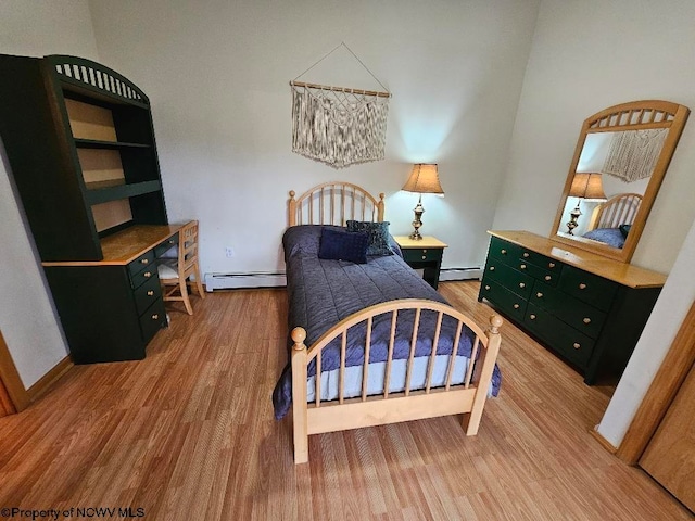 bedroom featuring a baseboard radiator and light hardwood / wood-style flooring