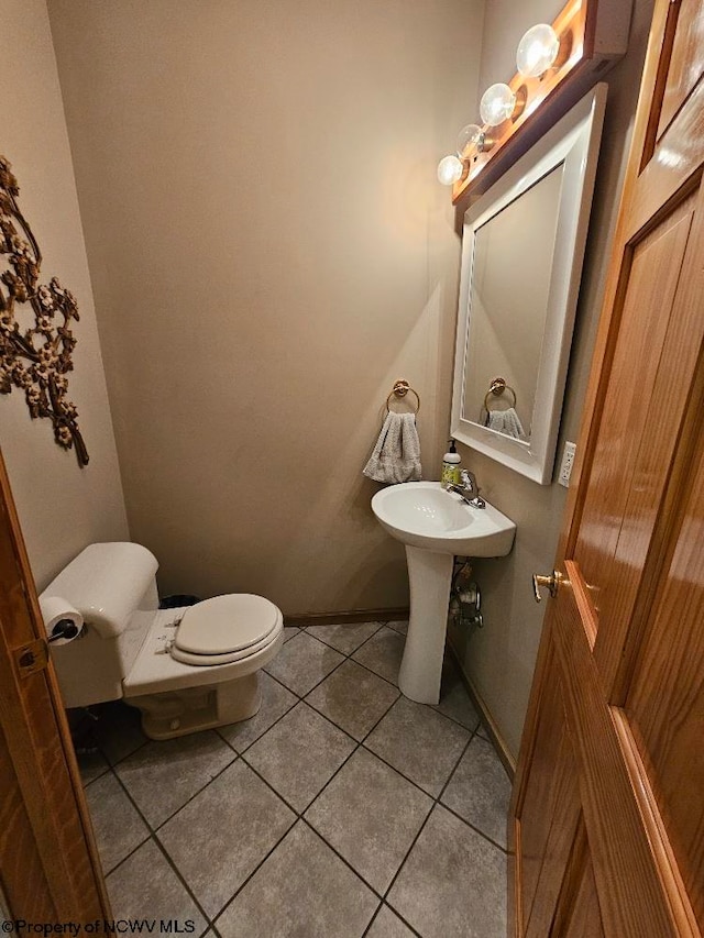 bathroom featuring toilet and tile floors