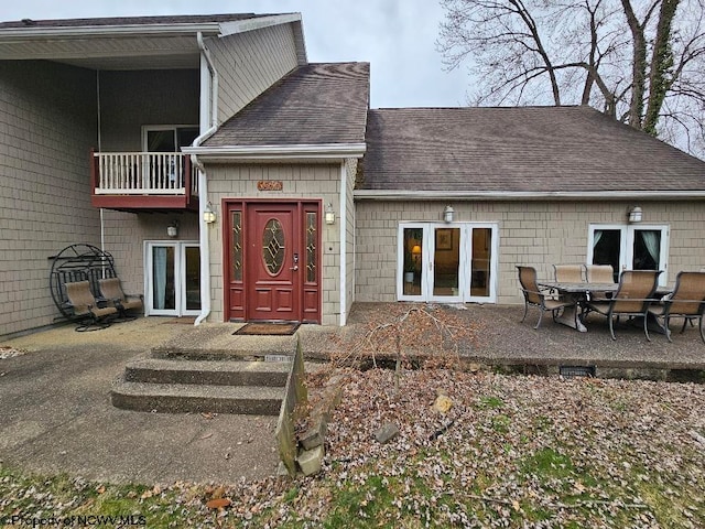 doorway to property featuring french doors, a balcony, and a patio area