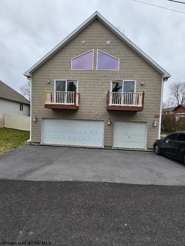 view of front of property featuring a balcony and a garage