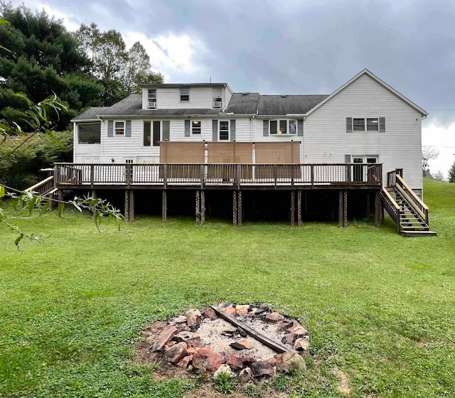 rear view of property featuring a wooden deck and a lawn