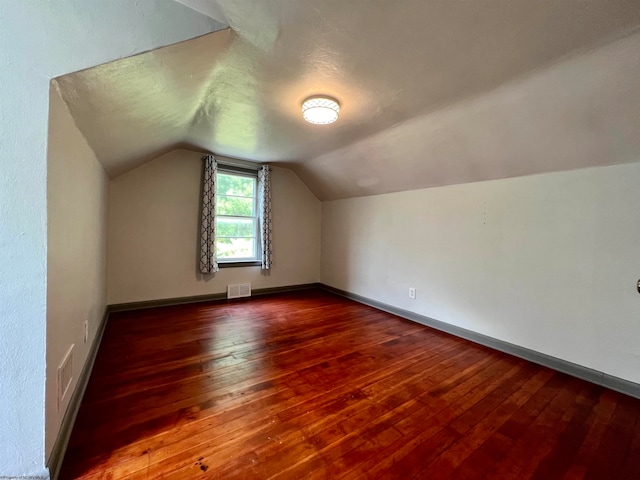 bonus room with vaulted ceiling and dark hardwood / wood-style flooring