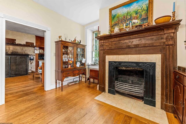 living room with light hardwood / wood-style flooring and a tiled fireplace