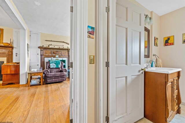 corridor with sink and light wood-type flooring