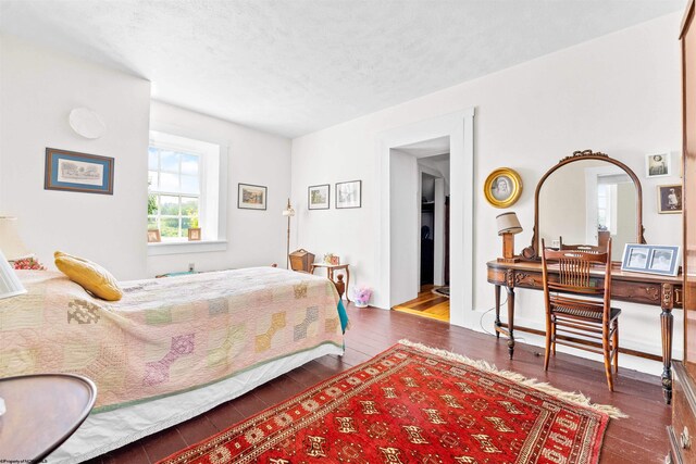 bedroom with a textured ceiling and dark wood-type flooring