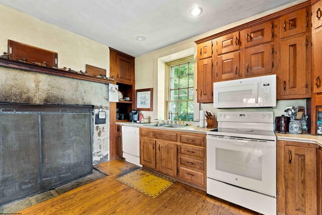 kitchen featuring dark wood-type flooring, white appliances, and sink