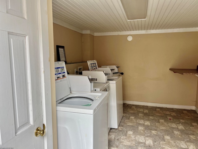 clothes washing area with light tile flooring, crown molding, wood ceiling, and washer and clothes dryer