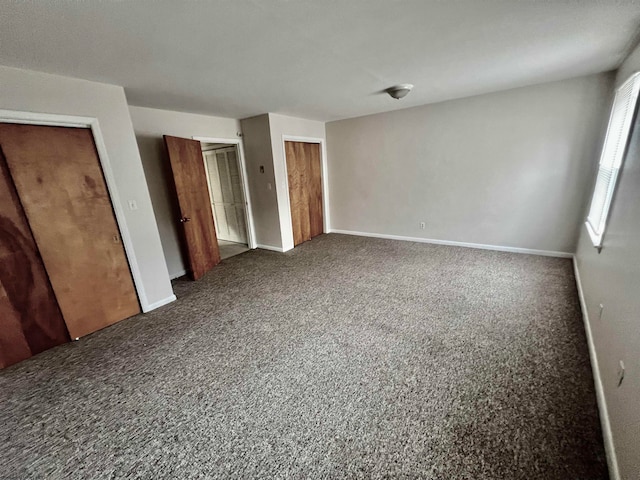 unfurnished bedroom with dark colored carpet