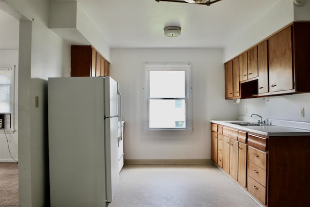 kitchen featuring light carpet, white refrigerator, and sink