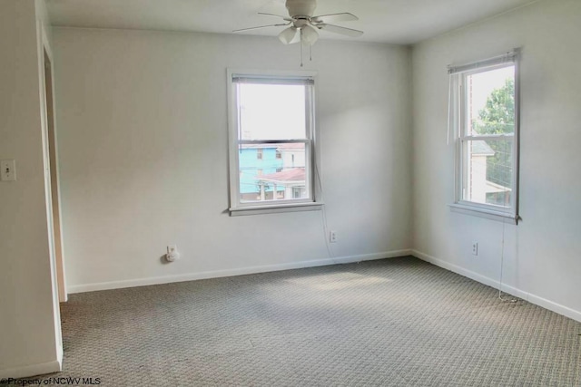 carpeted spare room featuring ceiling fan